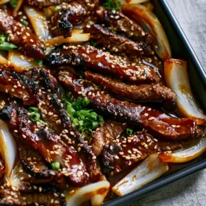 Close-up of charred crispy flank steak strips in a dark soy honey glaze. (easy recipe)