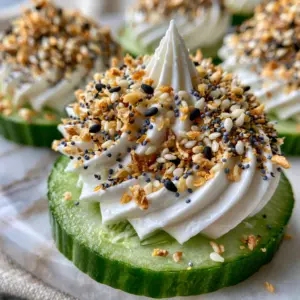 Macro photo of Everything Bagel Cucumber Bites showing textured cream cheese ridges and toasted garlic flakes.